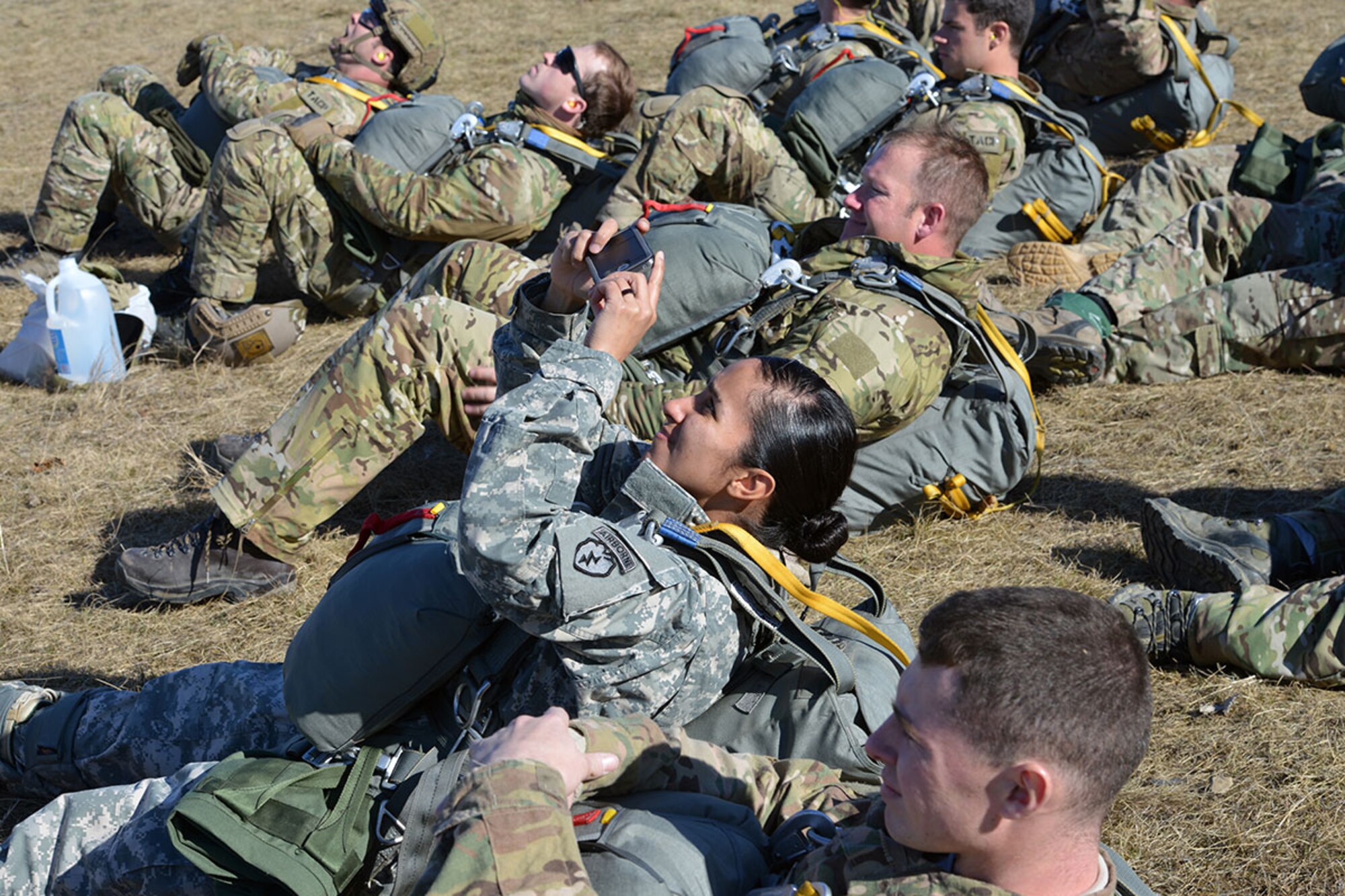 Airmen and Soldiers look on as fellow jumpers descend toward their target at Malemute Drop Zone, on Joint Base Elmendorf-Richardson, Alaska, April 18, 2016. Throughout the training exercise, service members performed parachute jumps out of UH-60 Black Hawks and C-17 Globemaster IIIs. (U.S. Air Force photo by Airman 1st Class Javier Alvarez)