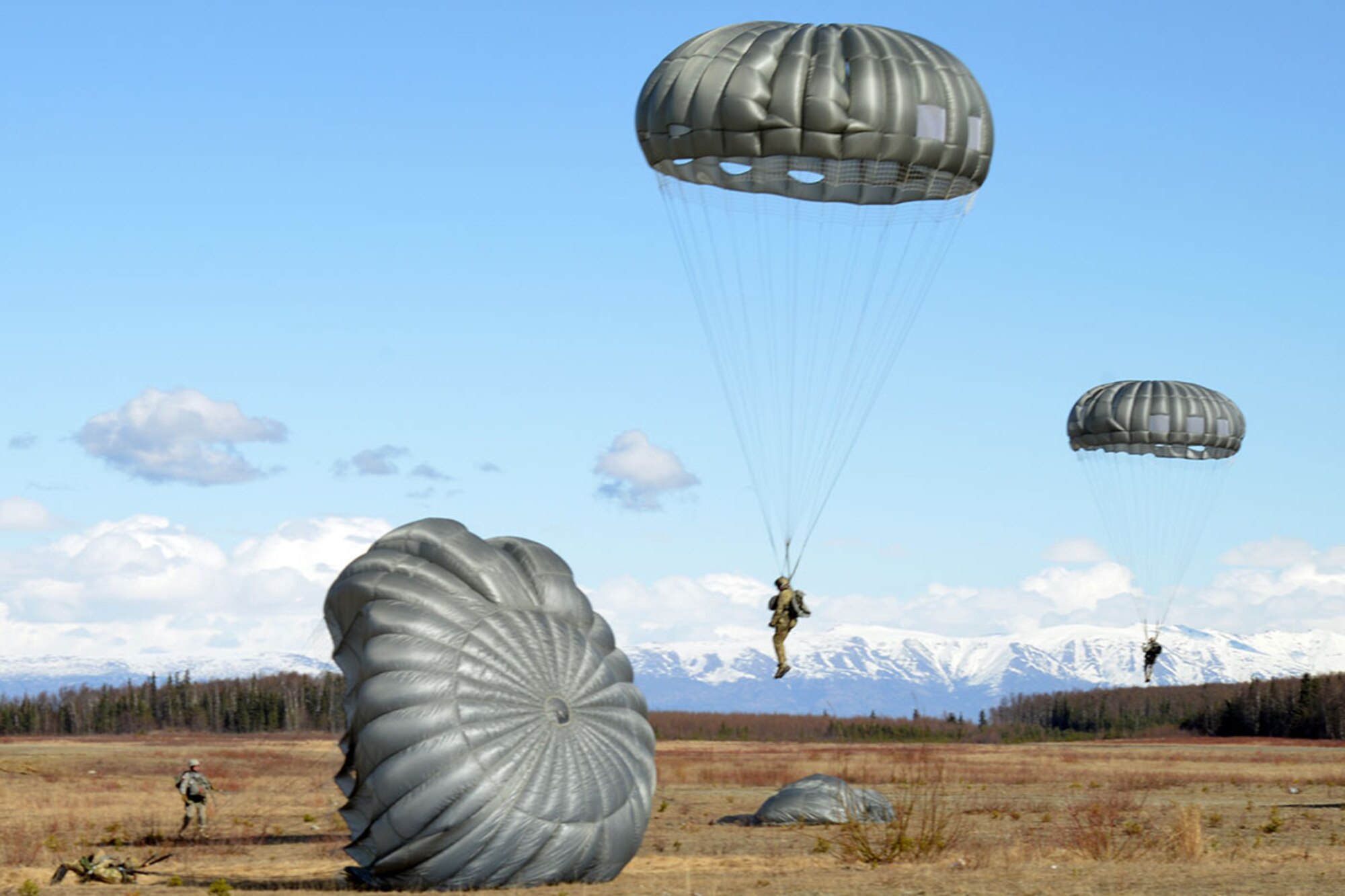 Airmen and Soldiers fall toward their target at Malemute Drop Zone, on Joint Base Elmendorf-Richardson, Alaska, April 18, 2016. Service members from seven units, throughout multiple installations participated in the jump. (U.S. Air Force photo by Airman 1st Class Javier Alvarez)