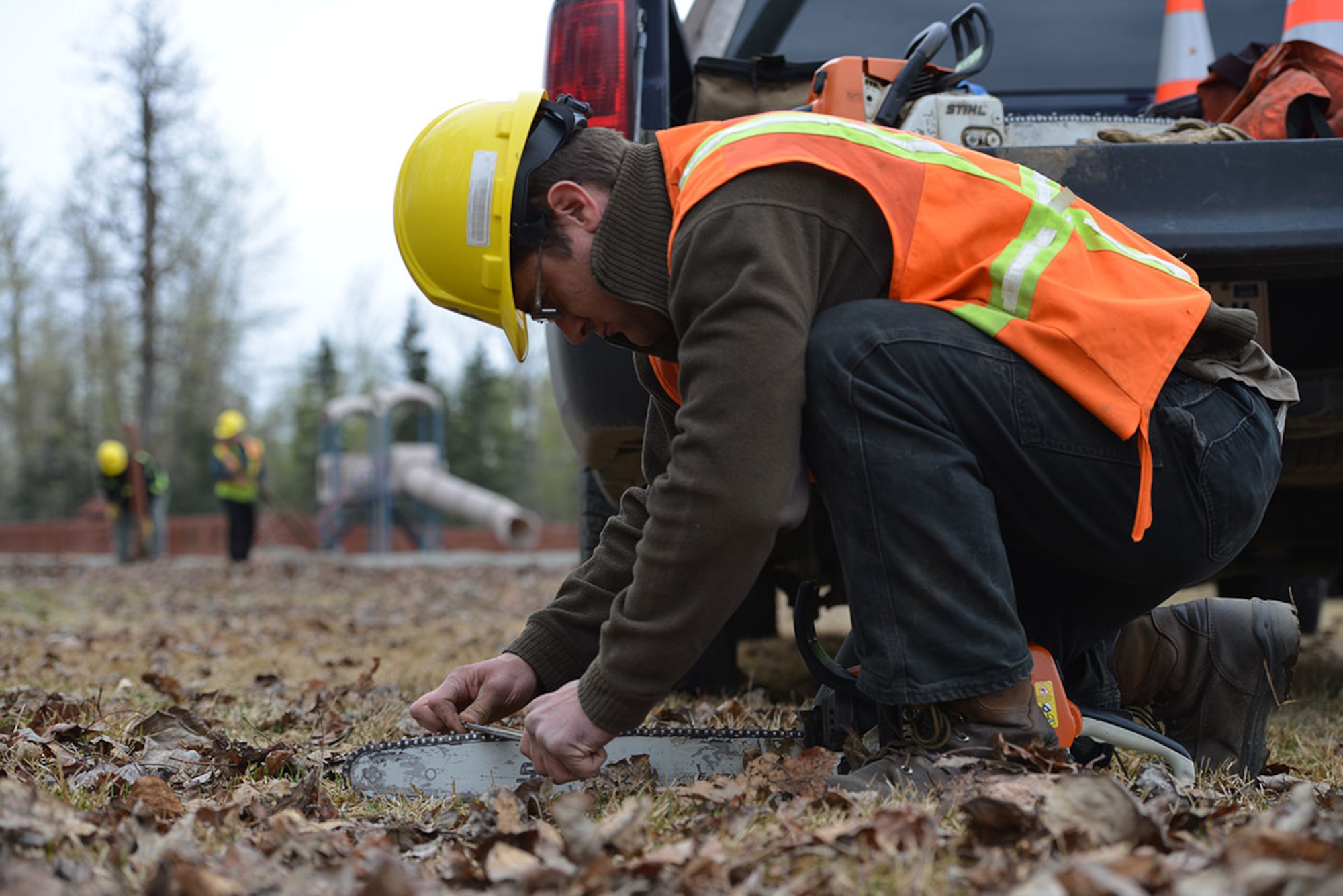 Jona Briggs, 773d Civil Engineer Squadron heavy equipment operator, sharpens the teeth on his chainsaw, at Cottonwood Park on Joint Base Elmendorf-Richardson, Alaska, April 25, 2016. Nine different play structures will be built following the removal of the current playground. (U.S. Air Force photo by Airman 1st Class Javier Alvarez)