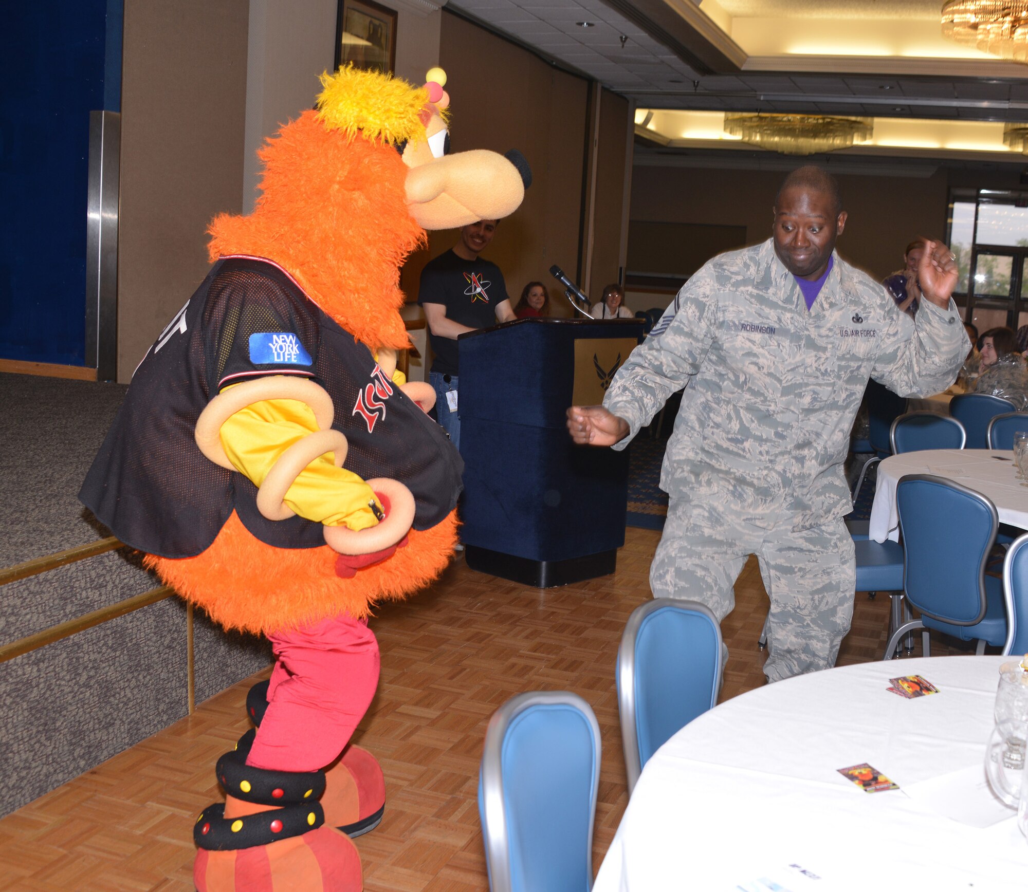 Senior Master Sgt. Maurice Robinson, senior enlisted adviser for the 377th Force Support Squadron, and Albuquerque Isotopes baseball team mascot Orbit dance at the squadron's quarterly awards ceremony at the Mountain View Club. Orbit was invited to attend to cheer the award winners. (Photo by Dennis Carlson)