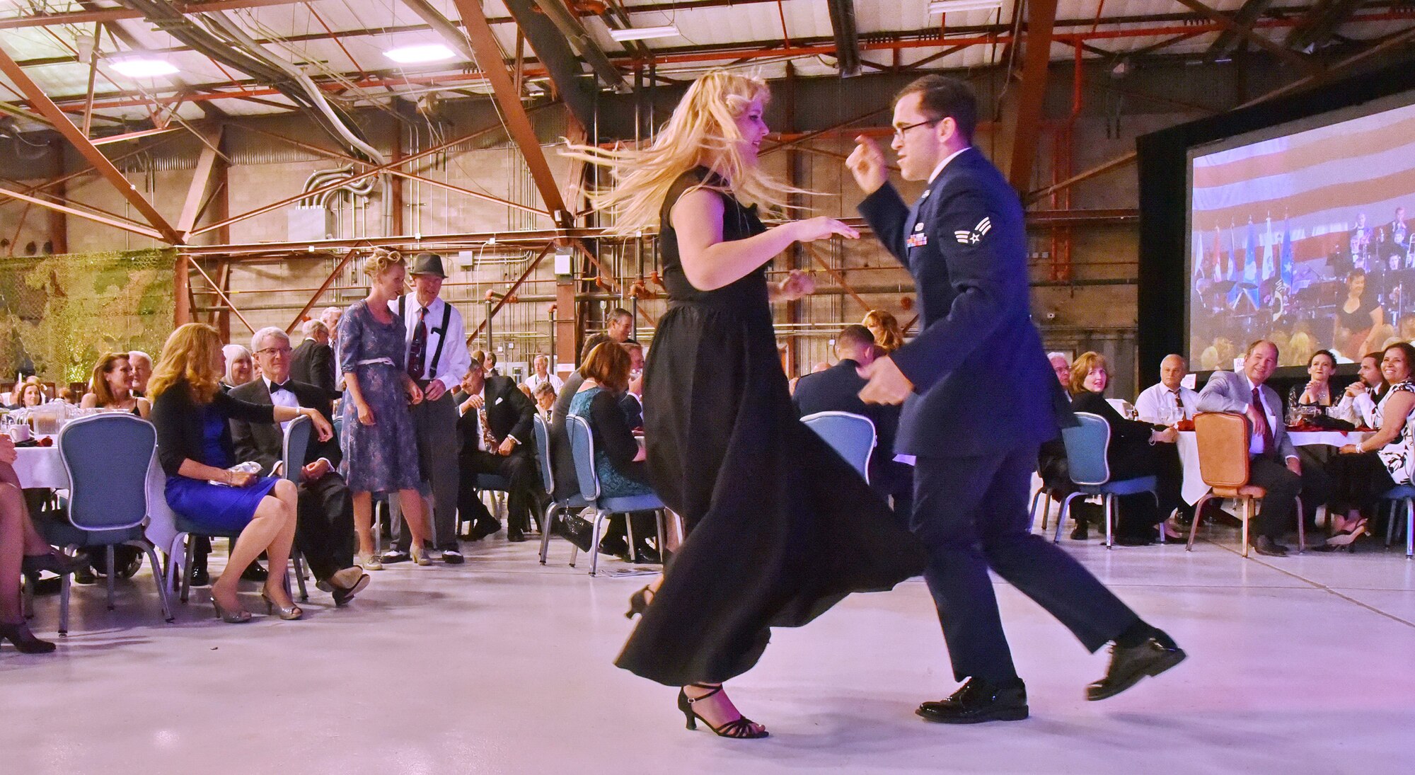 Senior Airman Jeffrey Whitlock and his partner dance the night away at an April 16 banquet celebrating Kirtland's 75th anniversary. About 500 people attended the banquet at the New Mexico Air National Guard’s 150th Special Operations Wing hangar. The banquet had a 1940s theme, to remember the opening of Albuquerque Army Air Base on Jan. 7, 1941. Period attire and static displays of World War II vehicles helped bring the theme to life. (Photo by Ken Moore)