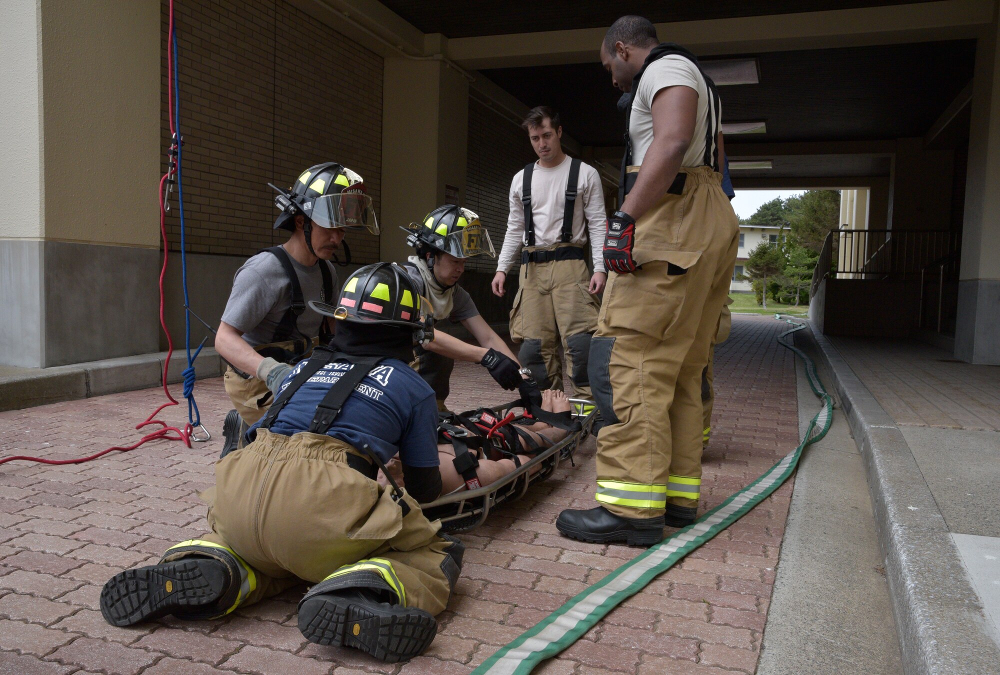 Firefighters assigned to the 35th Civil Engineer Squadron secure a mannequin to a litter during an emergency management exercise at Misawa Air Base, Japan, April 26, 2016. The EME simulated an 8.2 magnitude earthquake and affected numerous Airmen and civilians in a housing area. (U.S. Air Force photo by Senior Airman Patrick S. Ciccarone)
