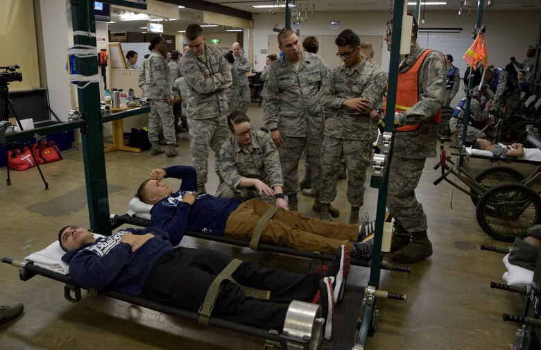 Airmen from the 35th Medical Group tend to two personnel simulating injuries during an emergency management exercise at Misawa Air Base, Japan, April 27, 2016. Aftershocks following a simulated 8.2 magnitude earthquake forced the 35 MDG to hold injured personnel in their expansion bay to be air-evacuated to another base for care. (U.S. Air Force photo by Senior Airman Patrick S. Ciccarone)
