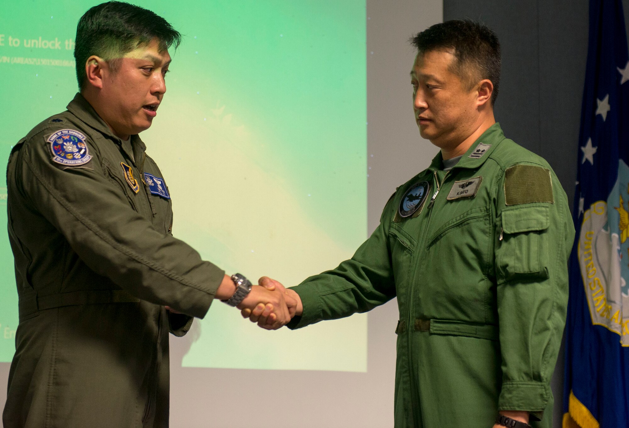 U.S. Air Force Lt. Col. Van Thai, 18th Operations Group deputy commander, shakes hands with Japan Air Self-Defense Force Lt. Col. Kaoru Sato, Southwestern Air Composite 304th Squadron commander, April 22, 2016, at Kadena Air Base, Japan. Fighter pilots from Naha Air Base’s 304th Fighter Squadron toured Kadena Air Base to integrate with the 44th Fighter Squadron. (U.S. Air Force photo by Senior Airman Omari Bernard)