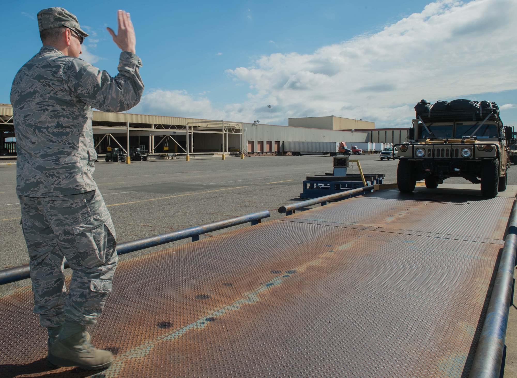 Col. Rhett Champagne, 821st Contingency Response Group commander, directs a Humvee onto a scale to check the weight and center balance before being loaded on a C-17 Globemaster lll aircraft before departing Travis Air Force Base, Calif., to support earthquake response efforts in Ecuador, April 21, 2016. The 621st Contingency Response Wing is providing an assessment team that includes subject matter liaisons in the realms of aerial port operations, cargo movement, material handling equipment, and communications. The 621st CRW maintains a ready corps of light, lean and agile mobility support forces able to respond as directed in order to meet combatant command requirements for humanitarian aid operations. (U.S. Air Force photo by Staff Sgt. Robert Hicks/Released)  