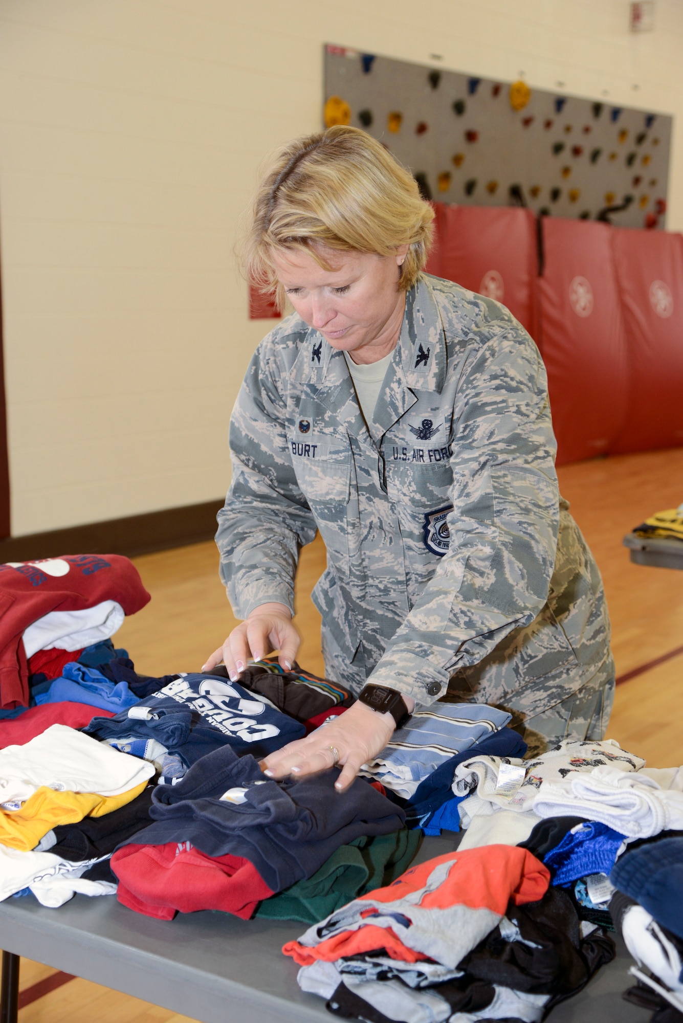 PETERSON AIR FORCE BASE, Colo. – Col. Deanna Burt, 50th Space Wing commander at Schriever Air Force Base, Colo. helps fold clothes during the annual clothing swap at the Peterson Youth Center April 23, 2016. Spouses and volunteers from Peterson and Schriever Air Force Bases organized the free event. (U.S. Air Force photo by Master Sgt. Jared Marquis)