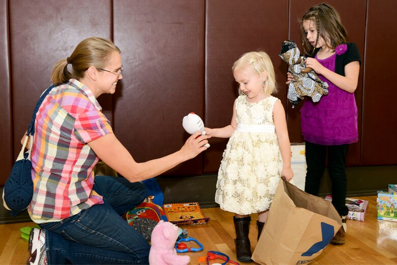 PETERSON AIR FORCE BASE, Colo. – Sarah Lynch and her daughters Liliana and Sophia look through donated toys during the annual clothing swap at the Peterson Youth Center April 23, 2016. Any leftover clothes were donated to the Peterson Thrift Shop and Hope & Home, a Colorado Springs Foster Organization.