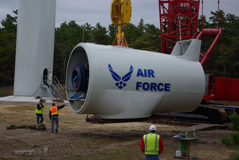 CAPE COD AIR FORCE STATION, Mass. – Crews hoist the turbine pod for a wind turbine at Cape Cod AFS in Massachusetts. Since the pair of 1.6 MW turbines went online in 2014 hundreds of thousands of dollars in energy credits were realized by the facility. In the current fiscal year they generated $19,000 in power above what is needed for the entire station. (Courtesy photo)