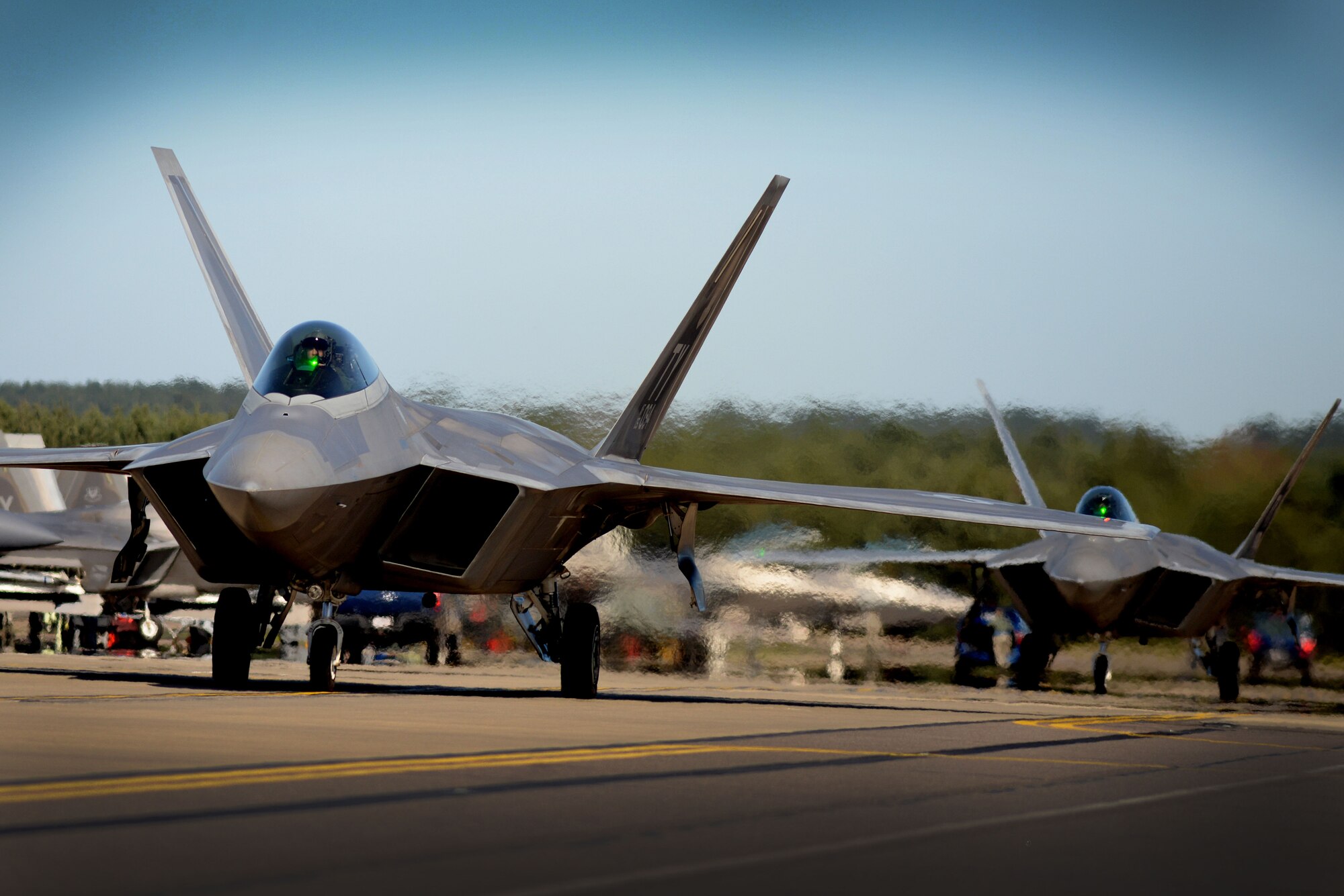 F-22 Raptors from the 95th Fighter Squadron taxi for takeoff April 20, at Royal Air Force Lakenheath, England. The F-22's conducted air-to-air fighter integration training with F-15 Strike Eagles from the 492nd Fighter Squadron, which allows the advanced aircraft a unique opportunity to fly alongside other U.S. Air Force aircraft, joint partners and NATO allies. (U.S. Air Force photo/ Tech. Sgt. Matthew Plew)