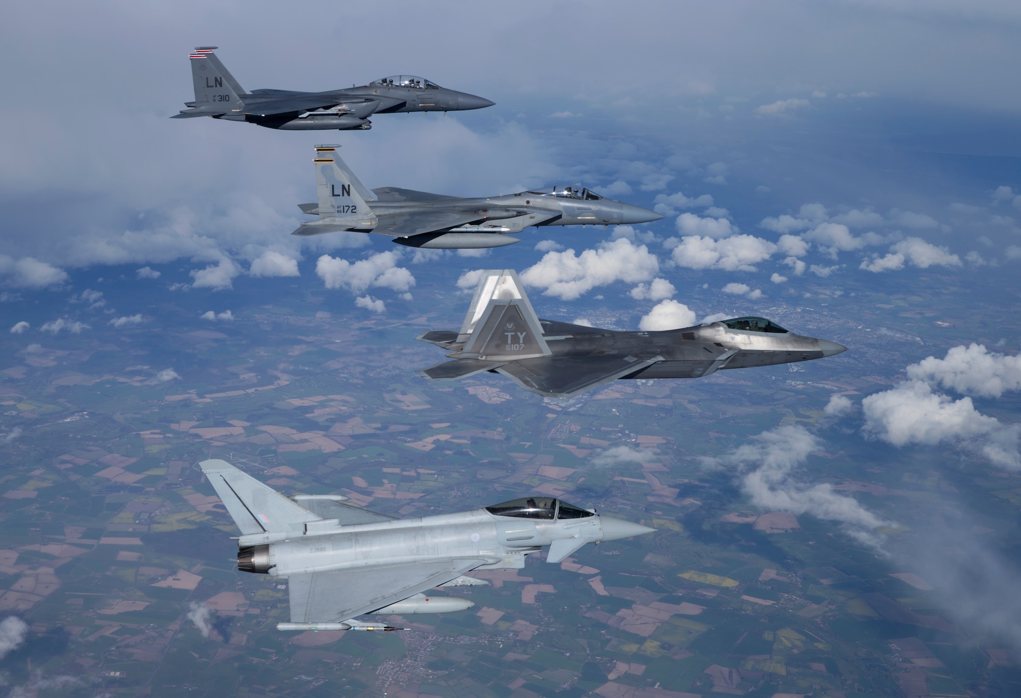 A four-ship formation consisting of a U.S. Air Force F-15E Strike Eagle from the 494th Fighter Squadron, an F-15 Eagle from the 493rd Fighter Squadron, an F-22A from the 95th Fighter Squadron, and a Royal Air Force Typhoon fly together during a training sortie April 26, 2016. 95th FS Airmen and aircraft are deployed from Tyndall Air Force Base, Fla., and will be conducting air training exercises with other U.S. and Royal Air Force aircraft over the next several weeks. (Courtesy photo by Jim Haseltine/Released)
