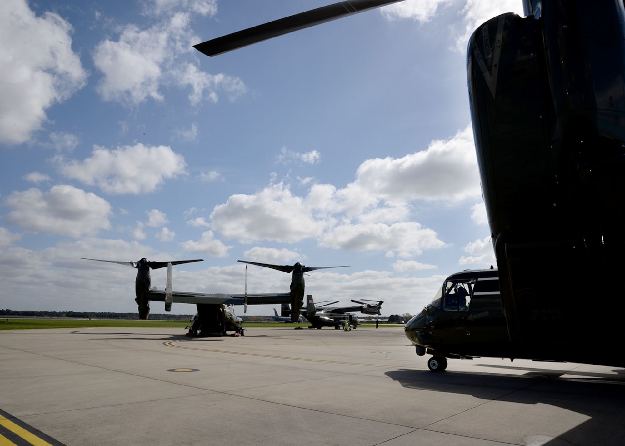 Three U.S. Marine Corps MV-22 Ospreys sit on the flightline April 19, 2016, on RAF Mildenhall, England. The multi-mission, tilt-rotor military aircraft, based out of Quantico, Va., were at RAF Mildenhall in support of the President’s visit to the United Kingdom for bilateral meetings and to the Hannover Messe being held in Germany. U.S. European Command and US Air Forces in Europe-Air Forces Africa were working with other government agencies in the U.K. and Germany to provide assistance as requested, to ensure a successful visit.  (U.S. Air Force photo by Karen Abeyasekere/Released)