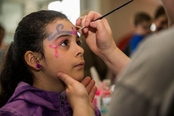 Jessica Kell, child of U.S. Air Force Staff Sgt. Luis Kell, a 52nd Logistics Readiness Squadron vehicle operations control center support NCO-in-charge, receives a face painting during the Spring Fling event in the Base Exchange at Spangdahlem Air Base, Germany, April 15, 2016. The Airman & Family Readiness Center hosted the event to raise awareness of the Exceptional Family Member Program and the service it provides for families. (U.S. Air Force photo by Airman 1st Class Timothy Kim/Released)