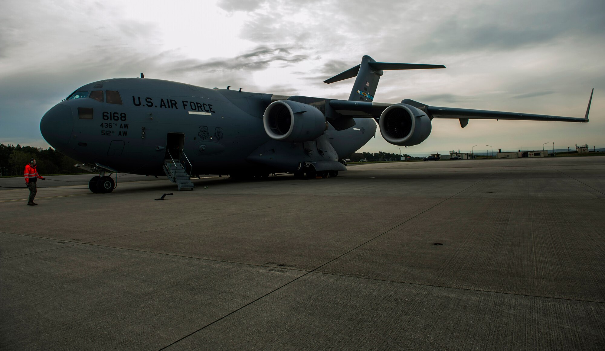 An Airman assigned to the 726th Air Mobility Squadron supervises a Boeing C-17 Globemaster III refueling process on the flightline at Spangdahlem Air Base, Germany, April 22, 2016. During the refuel, one Airman must monitor the communication line to ensure the completion of the process. (U.S. Air Force photo by Airman 1st Class Timothy Kim/Released)