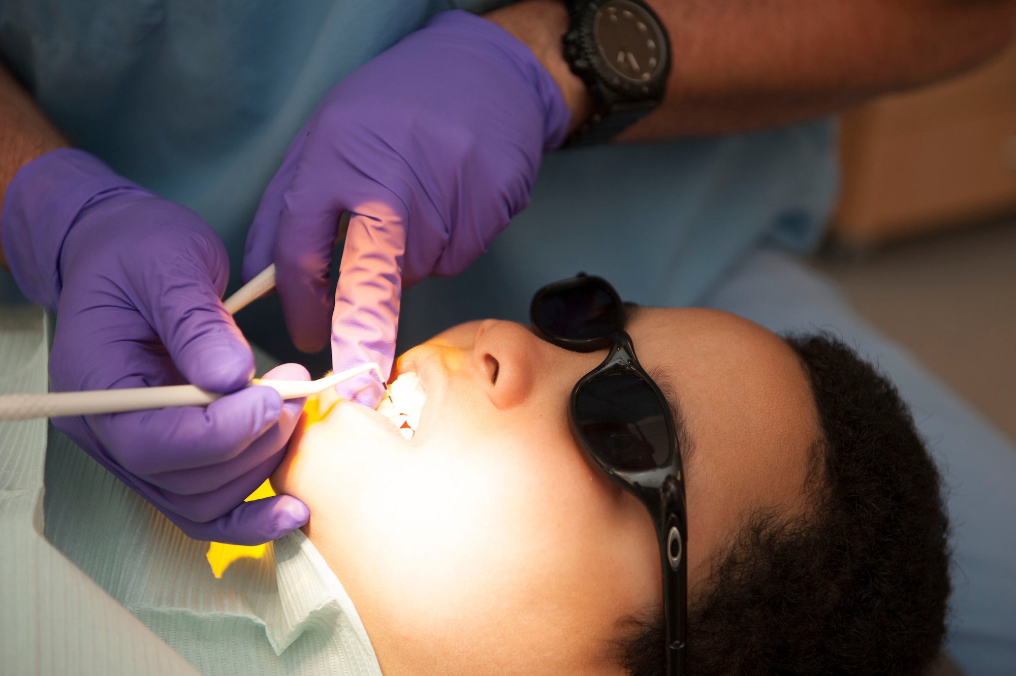 Latrell Phillips, son of U.S. Air Force Tech. Sgt. Melinda Reyes, 52nd Logistics Readiness Squadron outbound cargo activity NCO-in-charge, receives an inspection of the state of his oral hygiene during the 52nd Dental Squadron’s semi-annual children’s walk-in at Spangdahlem Air Base, Germany, April 22, 2016. The American Dental Association recommends young children have their teeth checked within six months of their first appointment to ensure parents follow proper cleaning techniques. (U.S. Air Force photo by Airman 1st Class Timothy Kim/Released)