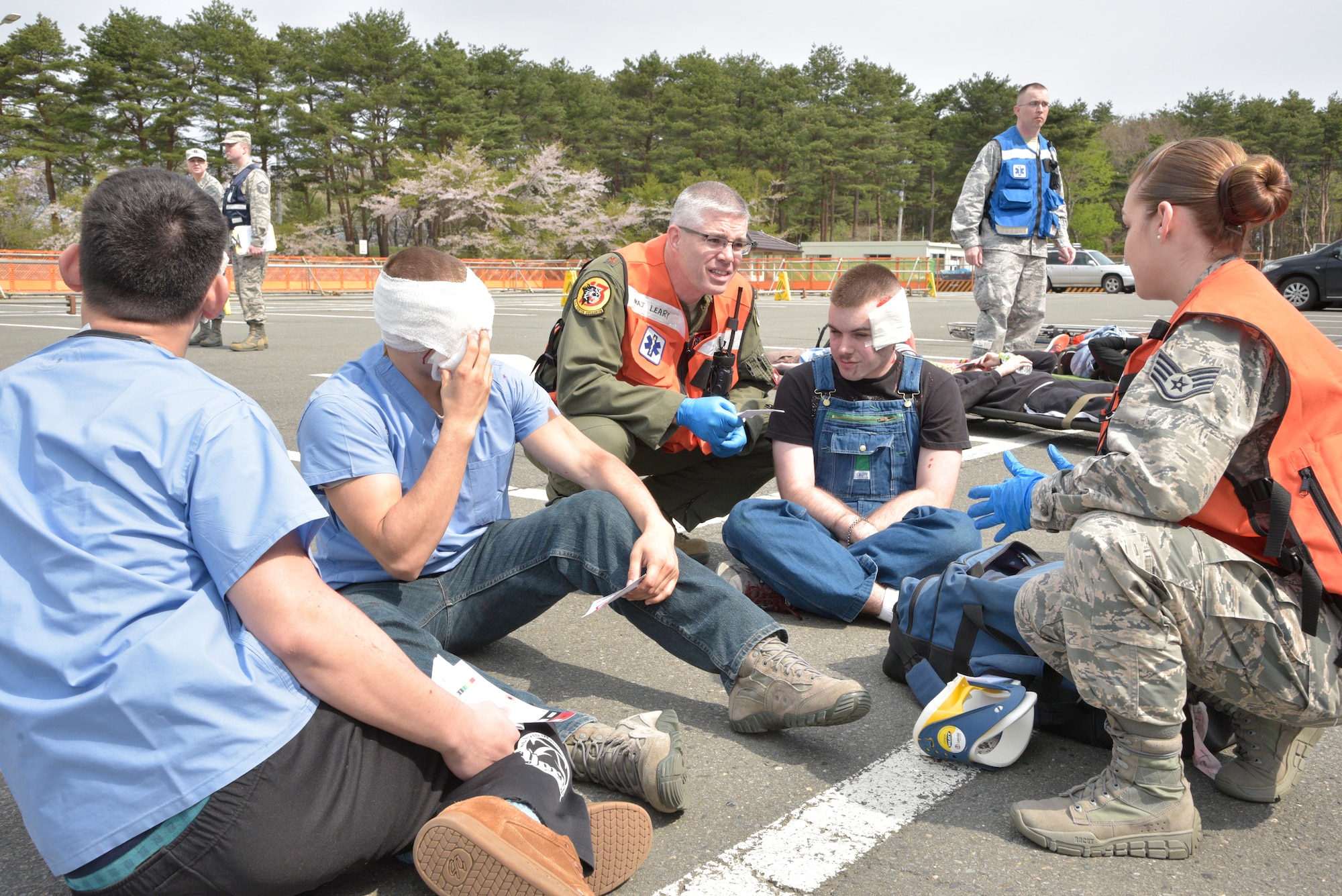 U.S. Air Force Maj. David Leary, 35th Aerospace Medicine Squadron flight surgeon, center, tends to a simulated injured civilian during an emergency management exercise at Misawa Air Base, Japan, April 26, 2016. After a simulated 8.2. magnitude earthquake struck the area, response agencies from around the base rushed to a housing area tower, tending to any injured on scene. (U.S. Air Force photo by Senior Airman Patrick S. Ciccarone) 