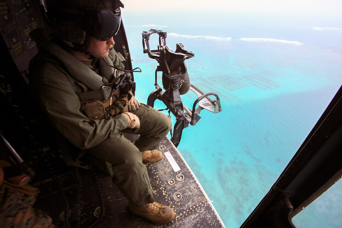 In this photo, Sgt. Jeffrey L. Allen scopes out the terrain from his seat in a UH-1Y Huey, April 8, 2016, at Marine Corps Air Station Futenma, Okinawa, Japan. Allen, along with other crew chiefs and aircraft maintainers, may work up to 16 hours a day performing maintenance and checks on aircraft to ensure safe missions. Allen, from Ennis, Texas, is with Marine Light Attack Helicopter Squadron 167, currently supporting Marine Aircraft Group 36, 1st Marine Aircraft Wing, III Marine Expeditionary Force, under the unit deployment program. 