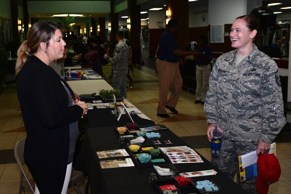Master Sgt. Holly Parkman, 554th RED HORSE resource adviser, receives information on wellness products from a vendor at the Health and Fitness Fair April 27, 2016, at Andersen Air Force Base, Guam. Vendors at the fair provided information about local produce, fitness and dietary products, natural disaster preparedness, lifestyle choices, education and more. (U.S. Air Force photo by Airman 1st Class Jacob Skovo)