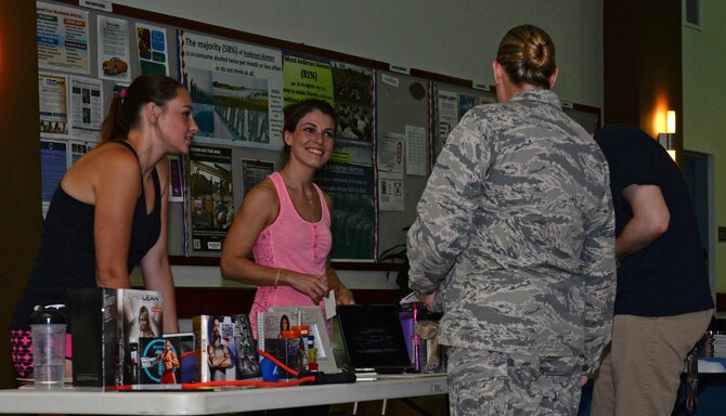 Andersen community members discuss fitness programs and dietary supplements at the Health and Fitness Fair April 27, 2016, at Andersen Air Force Base, Guam. Vendors at the fair set up booths to encourage Airmen and their families to live a healthy lifestyle and promote a variety of classes, services and products. (U.S. Air Force photo by Airman 1st Class Jacob Skovo)