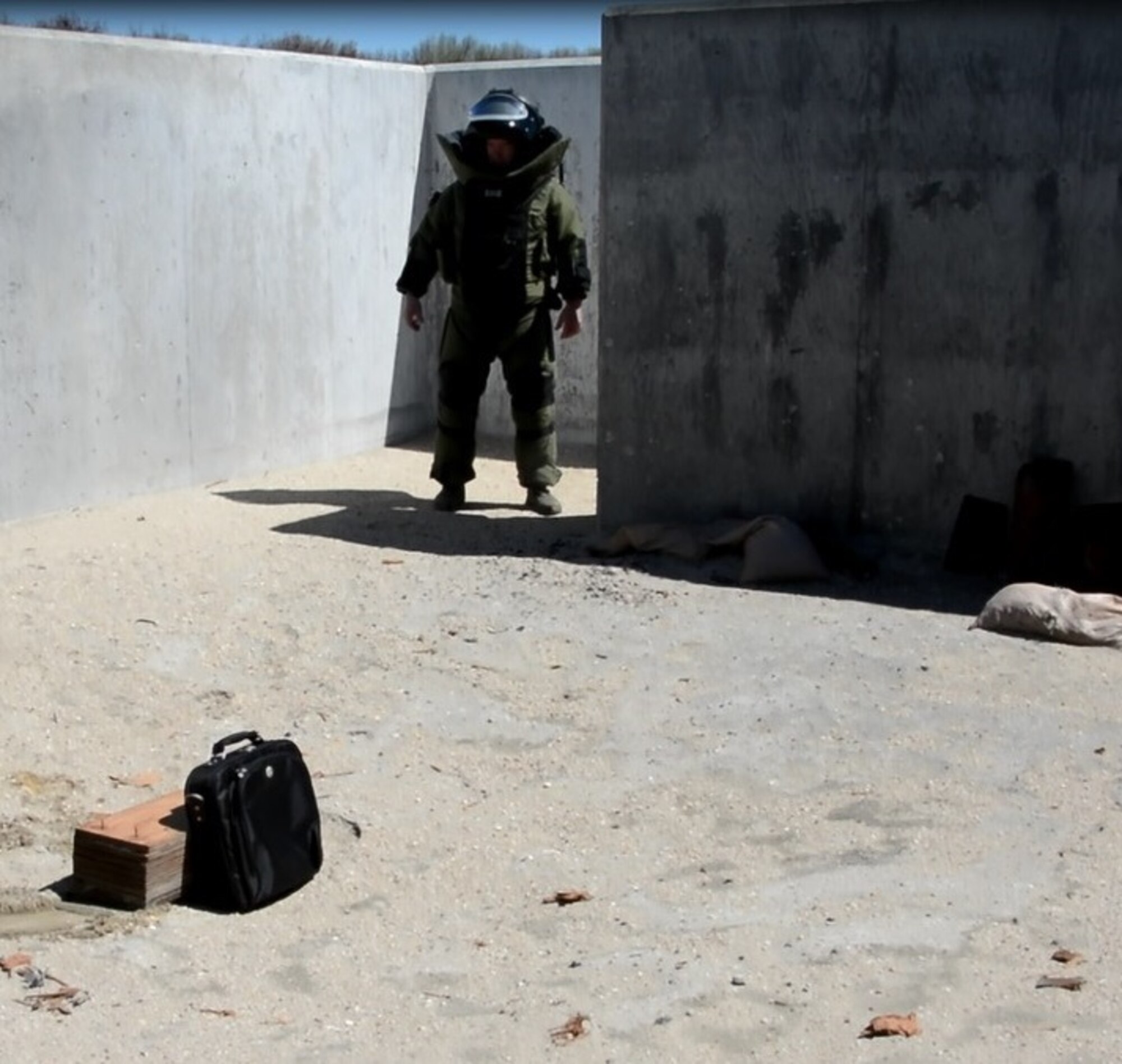 Staff Sgt. John Nelson, 512th Explosive Ordnance Flight, simulates inspecting a suspected improvised explosive device inside a computer bag during a training exercise April 3, 2016 at Dover Air Force Base, Delaware. Nelson was joined by his flight's program manager who evaluated his performance. (U.S. Air Force photo/Staff Sgt. Joe Yanik)