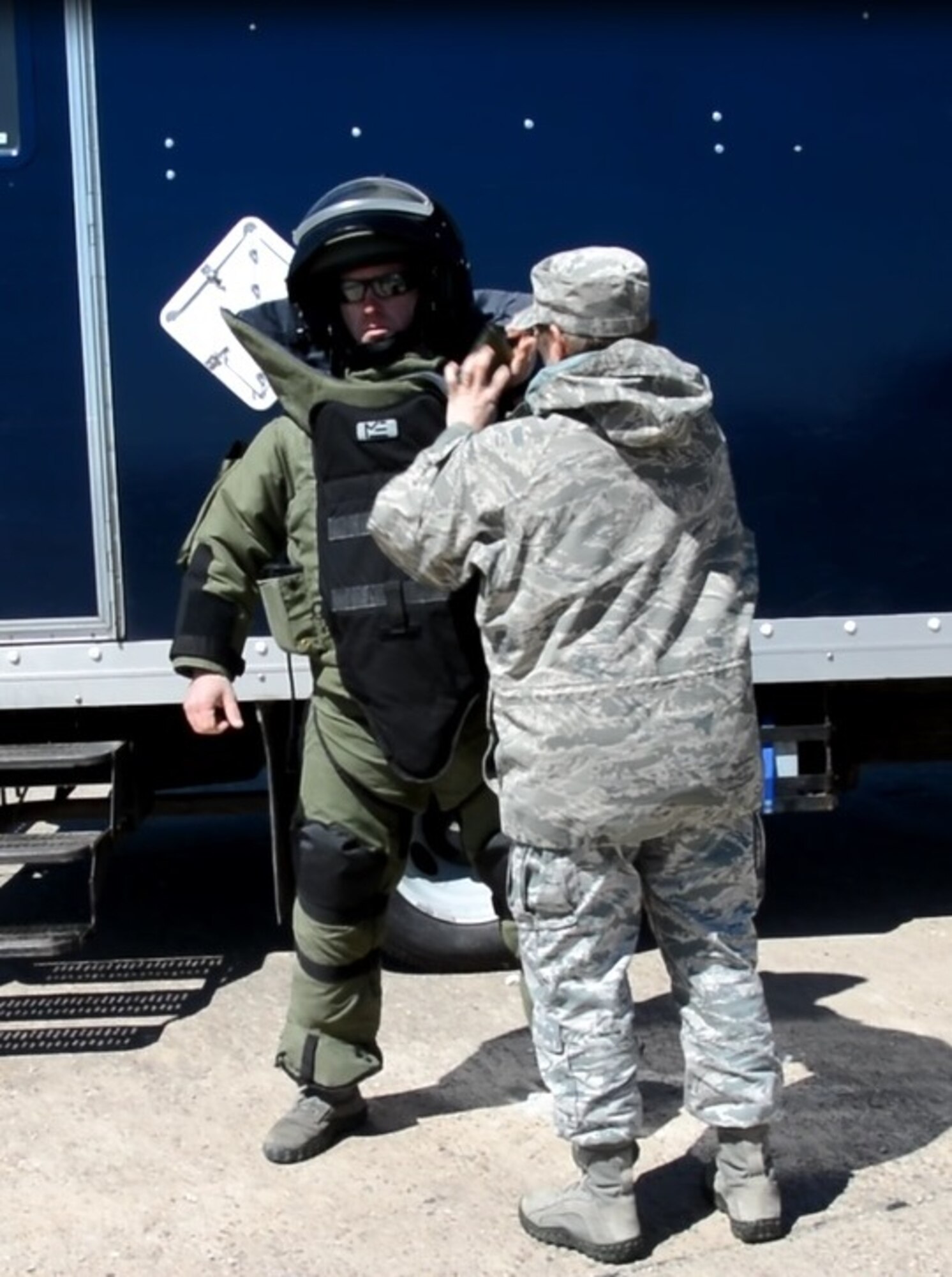 Master Sgt. Mary Kokoszka (right) assists Staff Sgt. John Nelson, both from the 512th Civil Engineer Squadron, with putting on his bomb suit during an improvised explosive device detonation training exercise April 3, 2016 at Dover Air Force Base, Delaware. Though already qualified to render safe a suspected IED, Nelson is required to stay current on this kind of training. (U.S. Air Force photo/Staff Sgt. Joe Yanik)