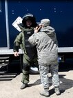 Master Sgt. Mary Kokoszka (right) assists Staff Sgt. John Nelson, both from the 512th Civil Engineer Squadron, with putting on his bomb suit during an improvised explosive device detonation training exercise April 3, 2016 at Dover Air Force Base, Delaware. Though already qualified to render safe a suspected IED, Nelson is required to stay current on this kind of training. (U.S. Air Force photo/Staff Sgt. Joe Yanik)