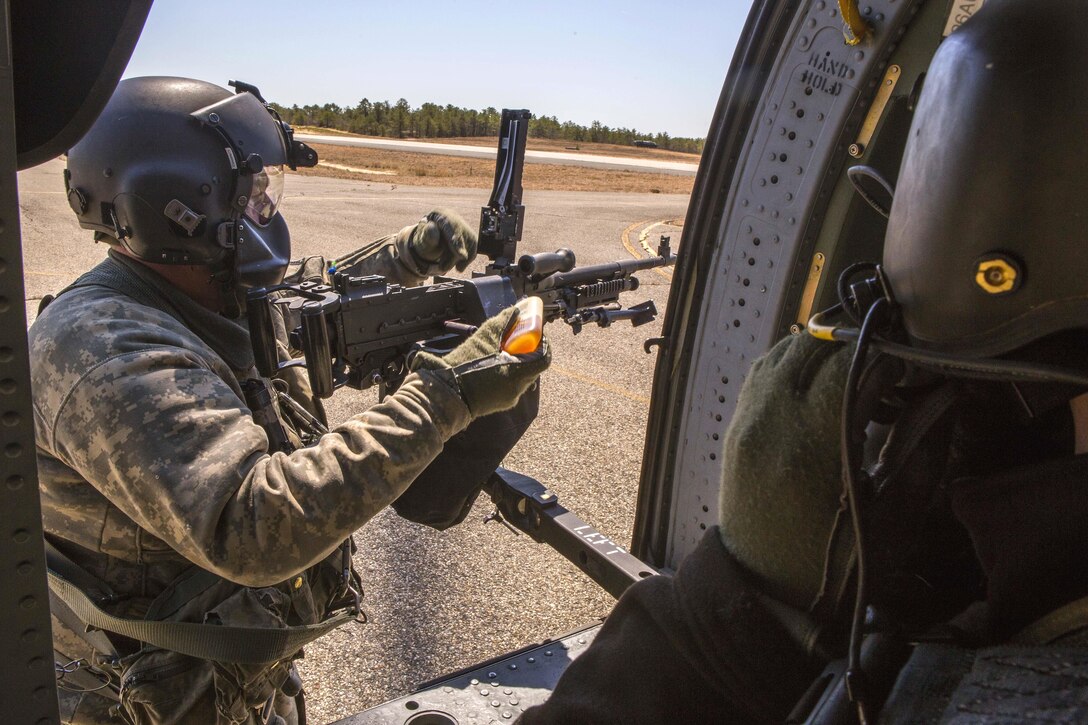 Army Staff Sgt. Paul Cimino, left, adds lubricant to an M240B machine gun attached to a UH-60 Black Hawk helicopter before participating in an aerial gunnery training exercise over Warren Grove Gunnery Range, N.J., April 15, 2016. Cimino is a master gunner assigned to the New Jersey Army National Guard’s 150th Assault Helicopter Battalion. Air National Guard photo by Master Sgt. Mark C. Olsen