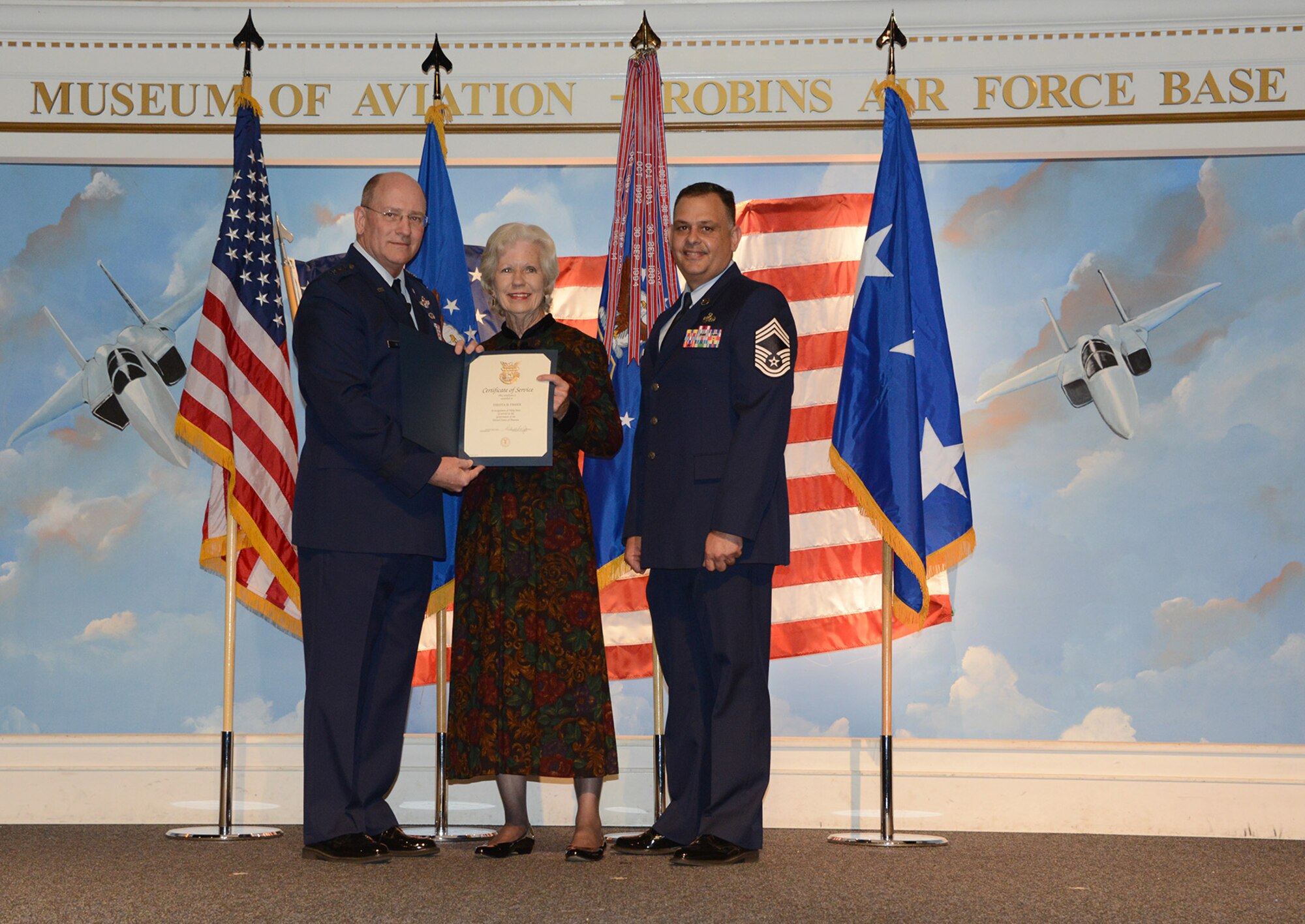 Lt. Gen. James F. Jackson, Air Force Reserve Command commander, and Chief Master Sgt. Florencio Lopez, chief enlisted manager for the HQ AFRC command staff, present Belle Fisher with her 50 year certificate of service at the AFRC commander's call April 26, 2016. (U.S. Air Force photo by Master Sgt. Chance Babin)