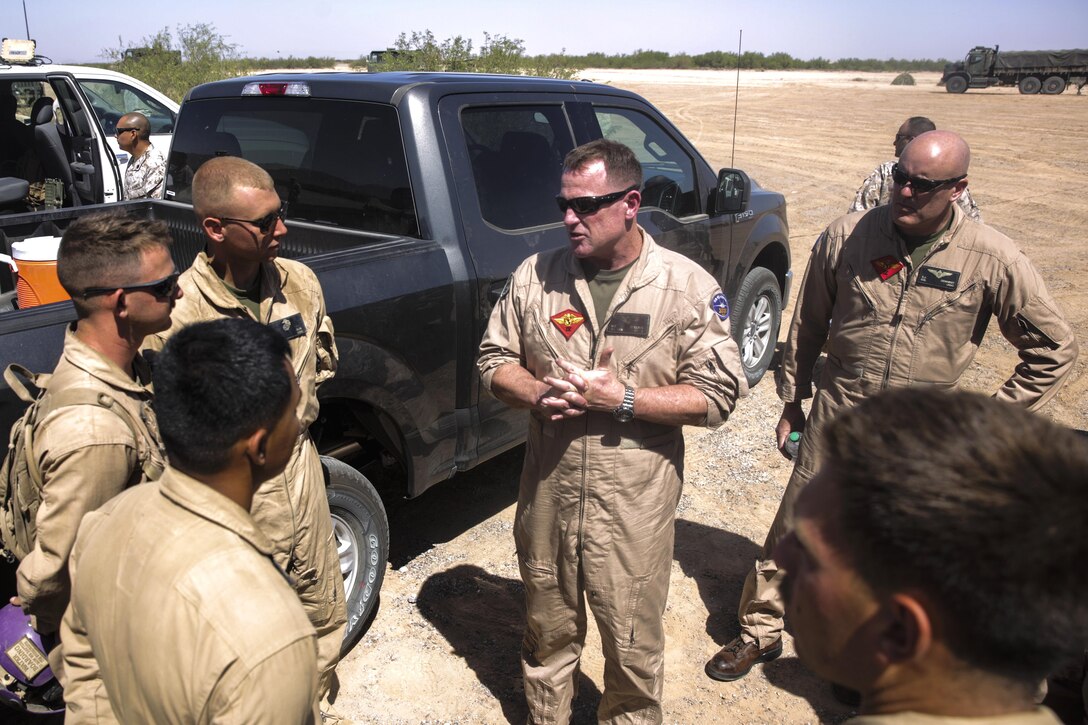 Marine Corps Maj. Gen. Willam T. Collins, center, commander, of the 4th Marine Aircraft Wing, speaks to Marines during Final Exercise 3 of the Weapons and Tactics Instructor course 2-16 at Stoval Airfield, near Yuma, Ariz., April 23, 2016. The Marines are assigned to the Marine Aviation Weapons and Tactics Squadron One and Marine Wing Support Squadron 274. The course provides standardized advanced tactical training and certification of unit instructor qualifications to support Marine aviation training and readiness and assists in developing and employing aviation weapons and tactics. Marine Corps photo by Lance Cpl. Zachary M. Ford