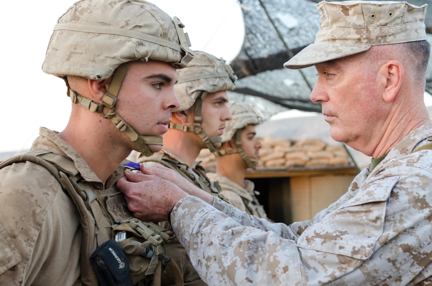 Chairman of the Joint Chiefs of Staff Gen. Joseph Dunford presents U.S. Marine Cpl. Adam J. Seanor, a native of Montgomery, Pennsylvania, with the Purple Heart during a ceremony at Kara Soar Base, Makhmur, Iraq, April 22, 2016. Seanor, a field artillery cannon crewman assigned to Battery E, 26th Marine Expeditionary Unit, was awarded his Purple Heart at the very site he was wounded March 19. (U.S. Army Photo by Staff Sgt. Peter J. Berardi)