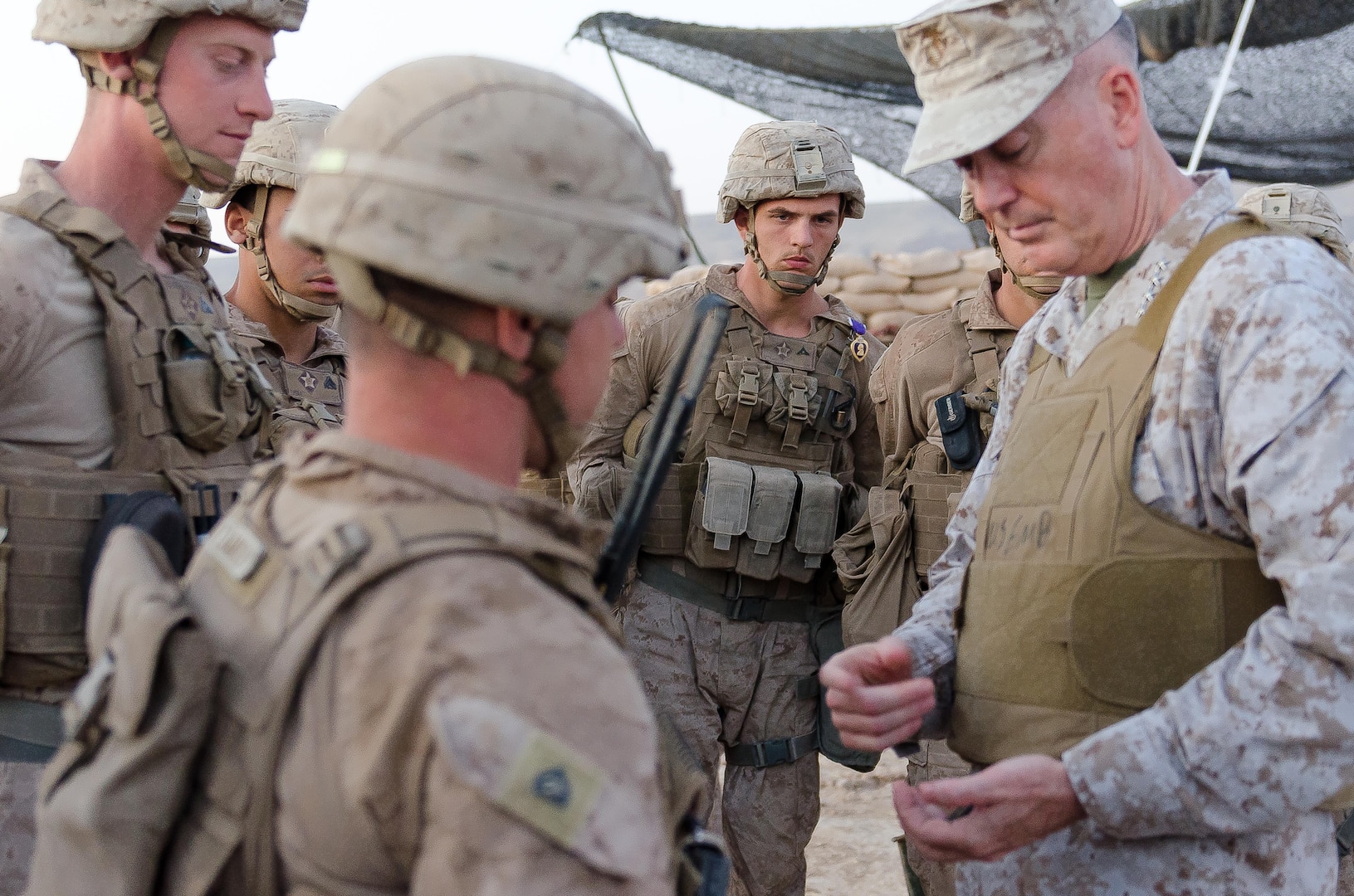 Chairman of the Joint Chiefs of Staff Gen. Joseph Dunford studies a unit coin presented to him by the U.S. Marines of Battery E, 26th Marine Expeditionary Unit, after an awards ceremony during which he presented four Marines the Purple Heart at the Kara Soar Base, Makhmur, Iraq, April 22, 2016. The Purple Hearts were awarded for wounds the Marines received during a rocket attack near their position March 19. Dunford was also presented with a primer from a mission they shot. (U.S. Army Photo by Staff Sgt. Peter J. Berardi)