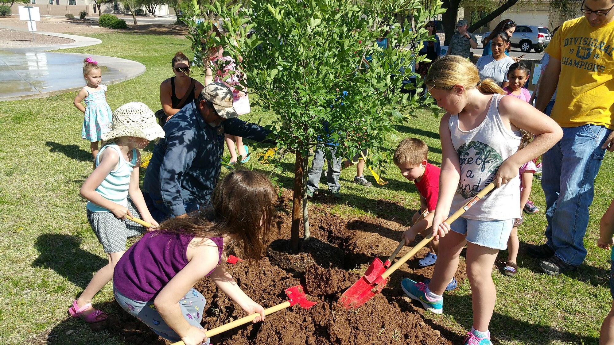 Children of Soaring Heights Communities plant an Ash tree at Davis-Monthan Air Force Base, Ariz., April 21, 2016. Soaring Heights celebrated Earth Day by inviting their residents to take part in planting a tree and learning about sustainability and conservation. (Courtesy photo)