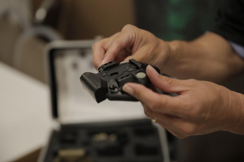 John Soto, vendor, Norotos Inc., demonstrates how to attach the night vision mounting equipment at the Officers’ Club during the Tactical and Technology Day Expo April 19, 2016. (Official Marine Corps photo by Pfc. Dave Flores/Released)