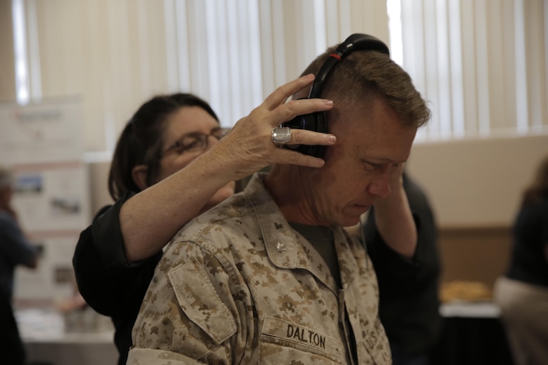 Lt. Col. Chris Dalton, academic department head, Marine Corps Logistics Operations Group, listens to theBoom, a microphone designed for clear audio even with loud background noise, at the Officers’ Club during the Tactical and Technology Day Expo April 19, 2016. (Official Marine Corps photo by Pfc. Dave Flores/Released)