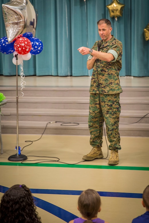 Lt. Col Sean Henrickson presents a student with an award during an Earth Day assembly at Middleton S. Elliott Elementary School aboard Laurel Bay April 22. Students drew Earth Day related artwork for a competition judged by the recycling department aboard Marine Corps Air Station Beaufort. Henrickson is the executive officer of MCAS Beaufort. 