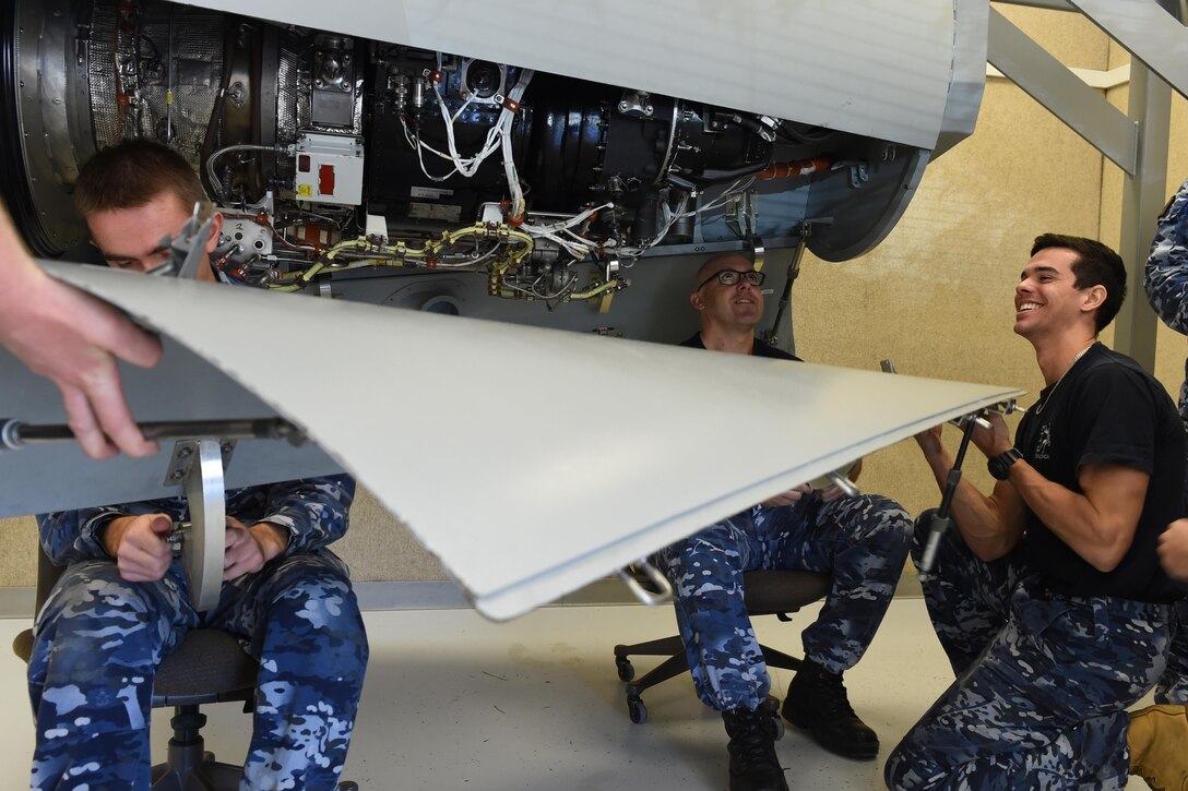 Airmen from the Royal Australian Air Force reinstall a cover door of a C-17 Globemaster III aircraft trainer auxiliary power unit April 19, 2016, at Joint Base Lewis-McChord, Wash. Because of McChord Fields advanced state of the art aircraft training facilities, the Royal Australian Air Force is one of the many foreign militaries that are trained at JBLM on C-17 maintenance. (U.S. Air Force photo/Senior Airman Jacob Jimenez)