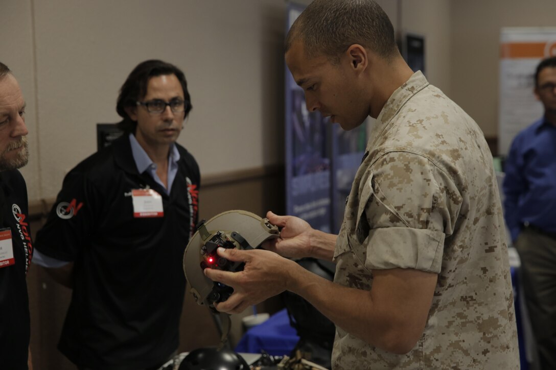 Petty Officer 2nd Class Tyellis Greenprice, corpsman, Navy Personnel Office, looks at night vision mounting equipment made by Norotos Inc., at the Officers’ Club during the Tactical and Technology Day Expo April 19, 2016. (Official Marine Corps photo by Pfc. Dave Flores/Released)