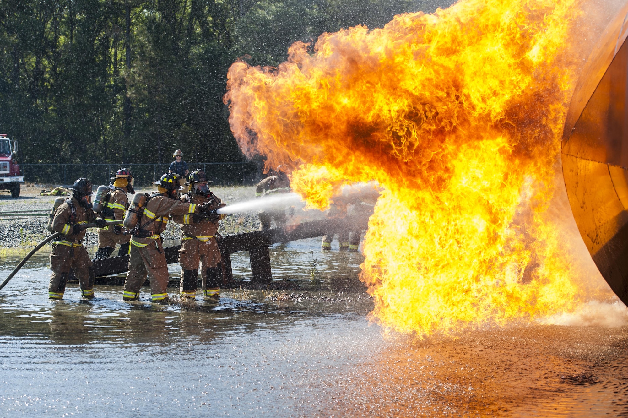 Firefighters from the 23d Civil Engineer Squadron and the Valdosta Fire Department smother a fire during aircraft live fire training, April 27, 2016, at Moody Air Force Base, Ga. Aircraft live fire training is conducted twice a year to ensure Airmen are always prepared to combat aircraft fuel fires. (U.S. Air Force photo by Airman 1st Class Lauren M. Hunter/Released) 