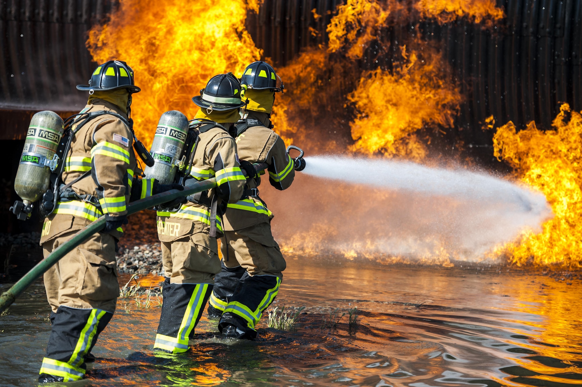 Firefighters from the 23d Civil Engineer Squadron and the Valdosta Fire Department put out an aircraft fire during aircraft live fire training, April 27, 2016, at Moody Air Force Base, Ga. Airmen extinguished a controlled propane fire, in order to simulate a jet fuel fire in an aircraft crash. (U.S. Air Force photo by Airman 1st Class Lauren M. Hunter/Released)