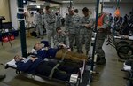 MISAWA AIR BASE, Japan (April 27, 2016) - Airmen from the 35th Medical Group (MDG) tend to two personnel simulating injuries during an emergency management exercise.  Aftershocks following a simulated 8.2 magnitude earthquake forced the 35 MDG to hold injured personnel in their expansion bay to be air-evacuated to another base for care.