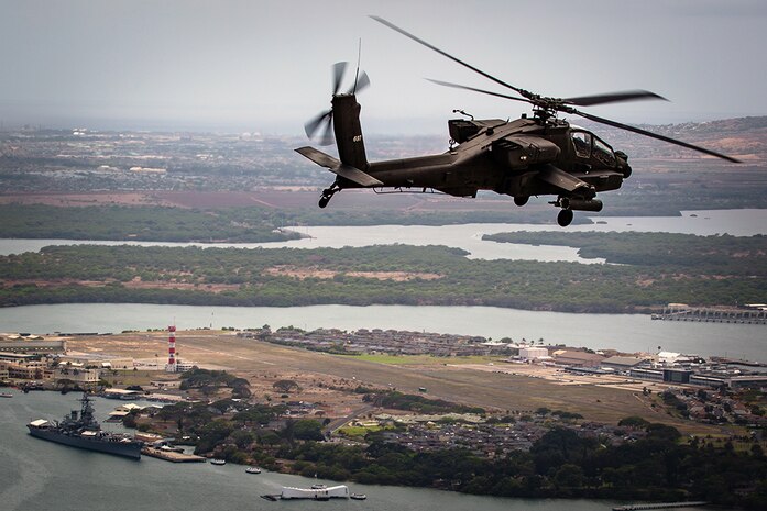 An AH-64D Apache from 2-6 Cavalry Squadron, 25th Combat Aviation brigade, flies above the USS Arizona Memorial and the USS Battleship Missouri Memorial in Pearl Harbor en route to Wheeler Army Airfield, April 24. The Apaches were reassigned to the 25th Combat Aviation Brigade from National Guard units as part of U.S. Army Aviation restructuring.