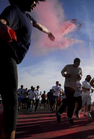 An Airman prepares to be showered with chalk during the 5K Color Run/Walk to raise awareness for April campaigns at Nellis Air Force Base, Nev., April 22, 2016. Each color on the run represented an agency and their awareness campaign. (U.S. Air Force photo by Airman 1st Class Kevin Tanenbaum)