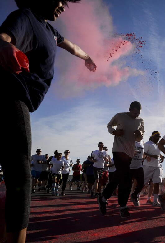 An Airman prepares to be showered with chalk during the 5K Color Run/Walk to raise awareness for April campaigns at Nellis Air Force Base, Nev., April 22, 2016. Each color on the run represented an agency and their awareness campaign. (U.S. Air Force photo by Airman 1st Class Kevin Tanenbaum)