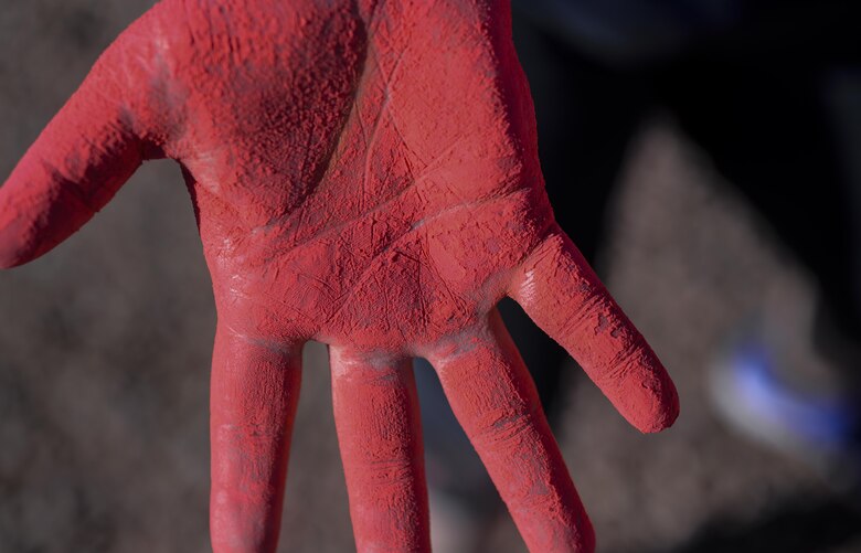 Member from Alcohol and Drug Prevention and Treatment program shows her hand after throwing chalk during the 5K Color Run/Walk to raise awareness for April campaigns at Nellis Air Force Base, Nev., April 22, 2016. The Chapel, Master Resilience, Airman & Family Readiness Center, Sexual Assault Prevention and Response, Exceptional Family Member Program, Family Advocacy, ADAPT/Mental Health, and Health & Wellness Center were all represented during the 5K Color Run. (U.S. Air Force photo by Airman 1st Class Kevin Tanenbaum)