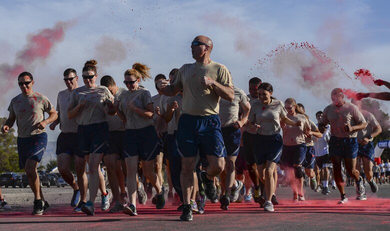 Airmen from the 99th Security Forces Squadron have colored chalk thrown at them while participating in the 5K Color Run/Walk at Nellis Air Force Base, Nev., April 22, 2016. Hundreds of Airmen and their families came out to participate in the event. (U.S. Air Force photo by Airman 1st Class Nathan Byrnes)