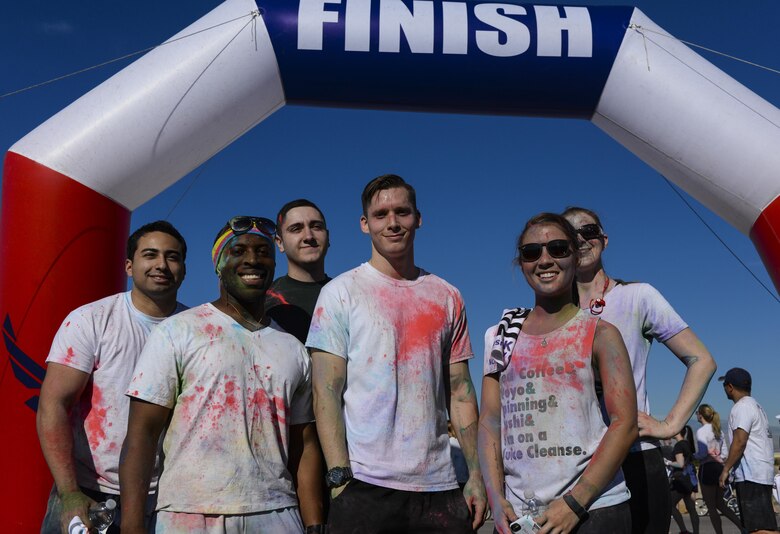 Airmen, assigned to the 57th Operations Support Squadron air traffic control tower, pose for a photo after completing the 5K Color Run/Walk at Nellis Air Force Base, Nev., April 22, 2016. The Color Run/Walk is an event where participates are doused from head to toe in different color chalks throughout the event and was a way to bring awareness to numerous campaigns taking place during April. (U.S. Air Force photo by Airman 1st Class Nathan Byrnes)