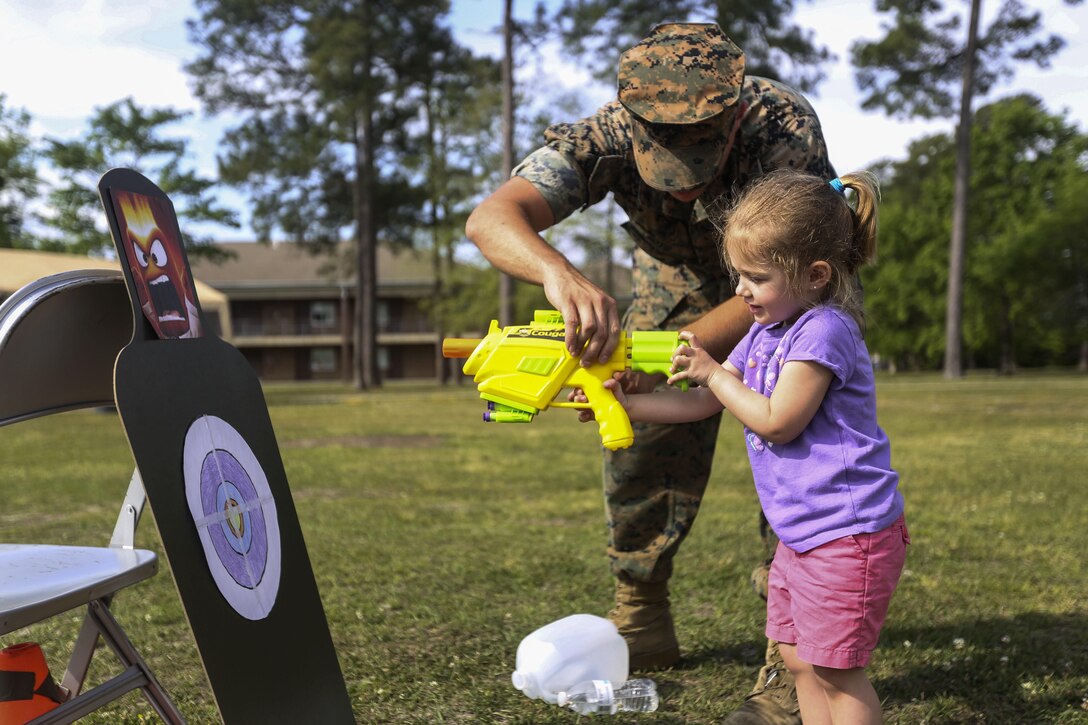 A Marine gives a girl a lesson on aiming at a target during Combat Logistics Regiment 2’s Bring Your Sons and Daughters to Work Day at Camp Lejeune, N.C., April 28, 2016. The event helped to bolster the unit’s morale and give families more time with one another. Marine Corps photo by Cpl. Dalton A. Precht