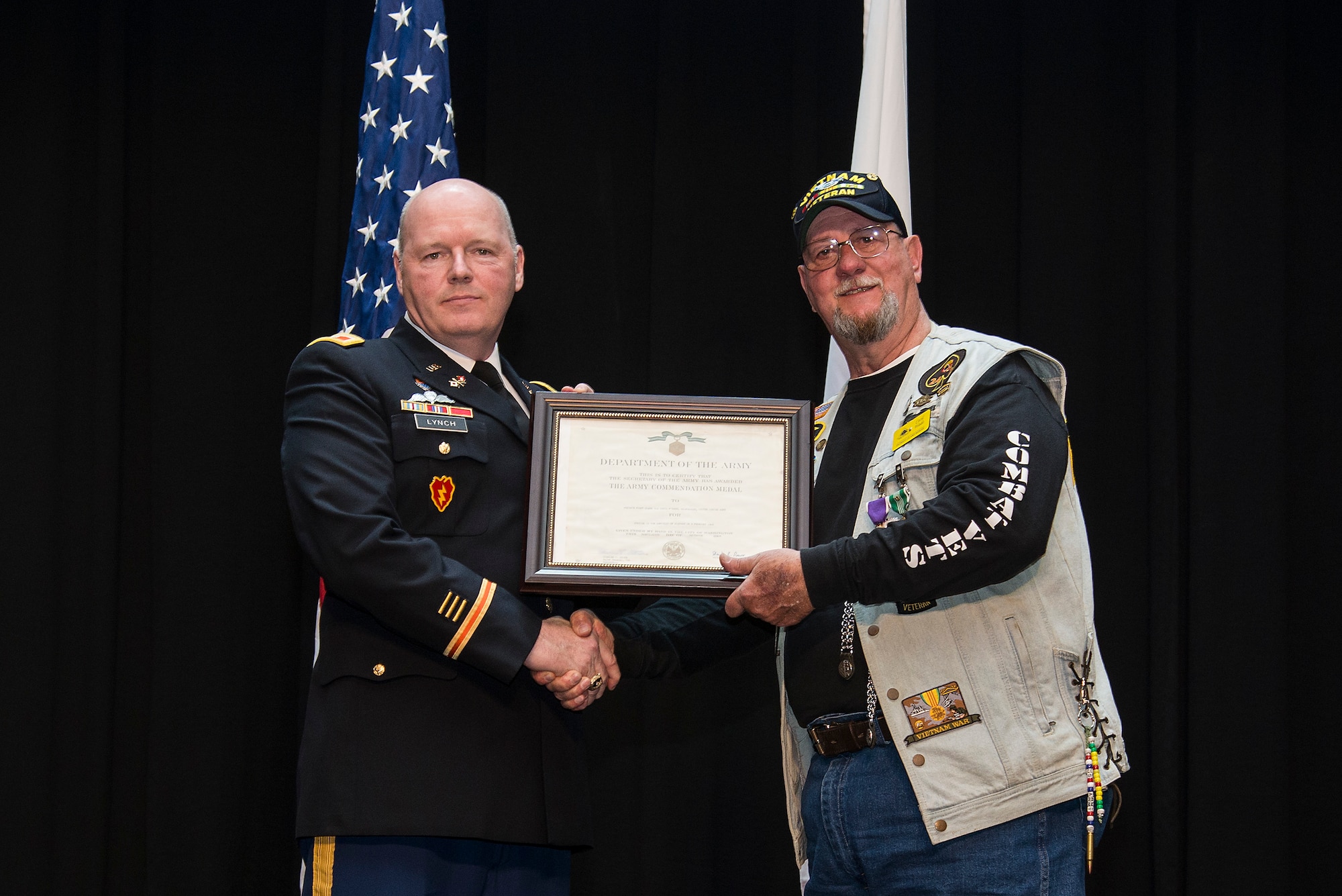 Army Col. Kevin Lynch presents Retired Army SGT. Cecil Wade with an Army Commendation Medal April 22, 2016 at Scott Air Force Base, Illinois. Wade was originally presented the Army Commendation Medal and Vietnam Service Medal when he returned from Vietnam. Since then the Department of the Army made the decision to add Valor to his Commendation Medal and another bronze star to his Vietnam Medal. (Air Force photo by Airman 1st Class Gwendalyn Smith)