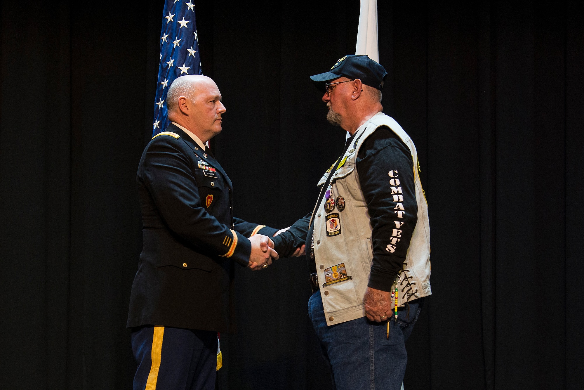 Army Col. Kevin Lynch presents Cecil Wade with a Purple Heart Medal, April 22, 2016 at Scott Air Force Base, Illinois, for injuries he received during Vietnam War. Wade was injured in Vietnam after jumping out of a helicopter he was forced to evacuate. He landed on one side and injured one of his legs critically. (Air Force photo by Airman 1st Class Gwendalyn Smith)