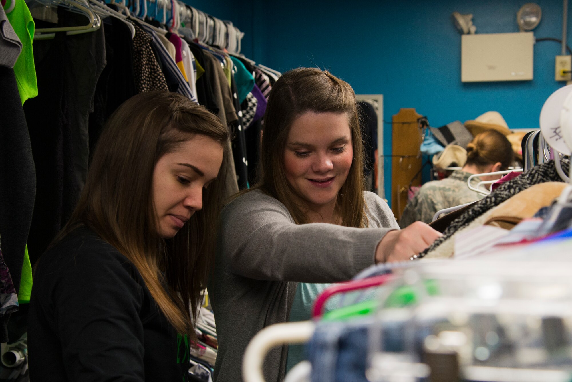 Shoppers look through clothing racks at the Chief Master Sgt. Gene Collins Airman’s Attic April 12, 2016 at Scott Air Force Base, Ill. The Airman’s Attic not only serves military members E-5 and below, but they also serve their dependents. (U.S. Air Force photo by Airman 1st Class Gwendalyn Smith)