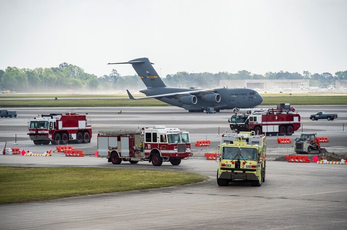 Firetrucks from the 628th Civil Engineer Squadron fire emergency services flight approach the scene during a confined space emergency extraction exercise, April 22, 2016, at Joint Base Charleston, S.C. The exercise simulated a person losing consciousness inside one of the four fuel tanks aboard a C-17 Globemaster III. (U.S. Air Force photo/Staff Sgt. Jared Trimarchi) 